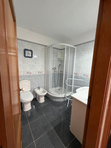 a bathroom with a toilet and a shower and a sink at Sunset Ria in Tavira