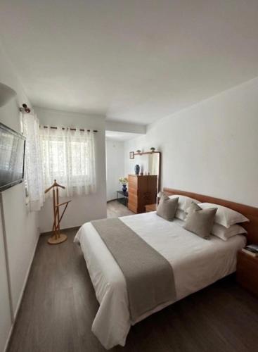 a bedroom with a large white bed and a television at Sunset Ria in Tavira