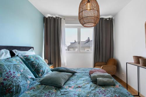 a bedroom with a bed with pillows and a window at La Parenthèse Paimpolaise in Paimpol
