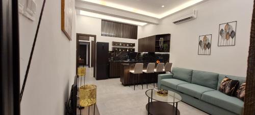 a living room with a green couch and a kitchen at Allure Suites in Larnaca