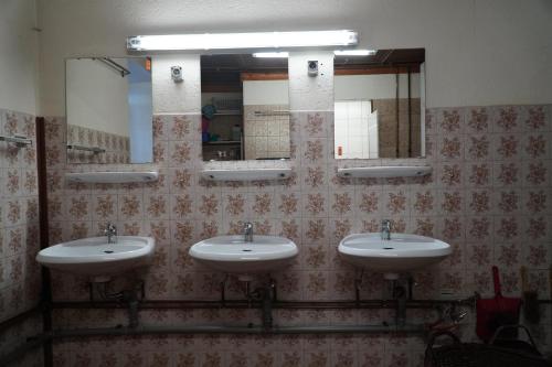 a bathroom with three sinks and a mirror at S'Platzl in Wenns