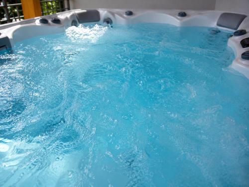a large pool of blue water in a swimming pool at Szent László Residence in Mátraszentimre