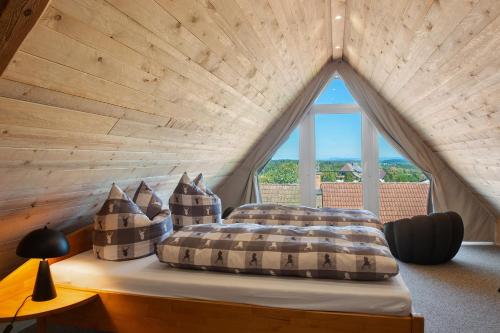 a bed in a room with a large window at Pension Ferienwohnung Baarblick in Donaueschingen