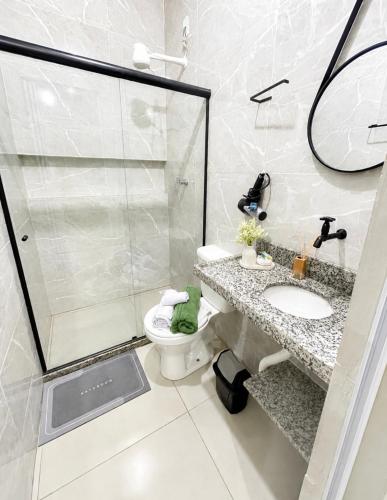 a bathroom with a shower and a toilet and a sink at Maria Lofts in Itaguaí