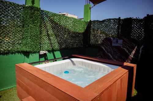 a hot tub in a wooden box with water at Rooftop Apartment with Garden and Jacuzzi in Durrës