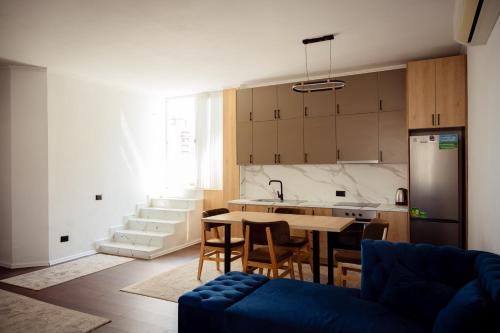a kitchen and living room with a table and chairs at Rooftop Apartment with Garden and Jacuzzi in Durrës