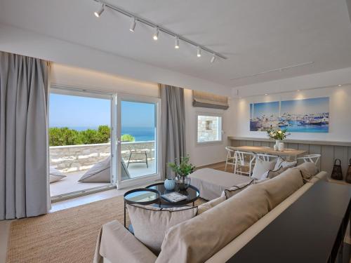 a living room with a couch and a large window at Sunset Rocks Residence in Parasporos