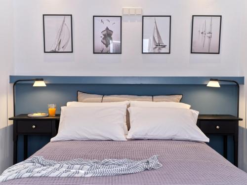 a bed with a blue head board with pictures on the wall at Sunset Rocks Residence in Parasporos