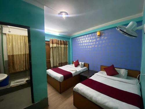 a hotel room with two beds and a mirror at Hotel New Bhojpure in Kathmandu