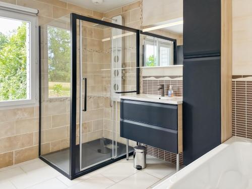 a bathroom with a shower and a sink at L'Abri Côtier, maison spacieuse avec jardin in Pendé