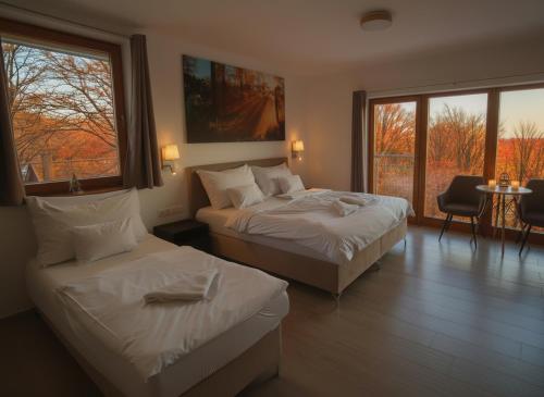 a hotel room with two beds and a balcony at Szent László Residence in Mátraszentimre