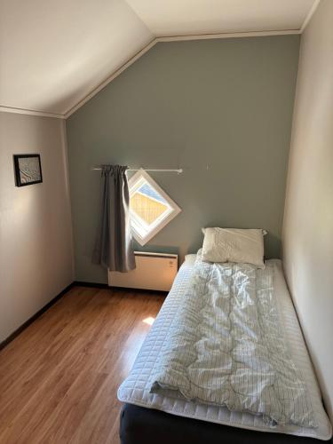 a small bedroom with a bed and a window at Strandvillan in Älandsbro