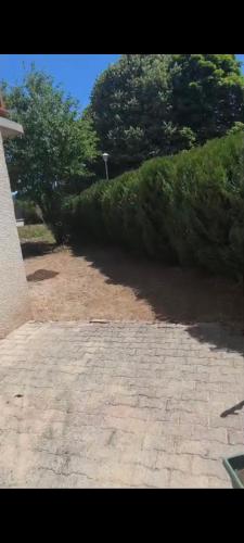 a brick walk way with bushes and trees in the background at Paradis Oyonnax in Bellignat