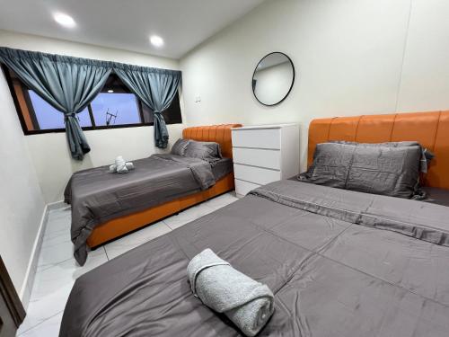 a bedroom with two beds and a mirror at Tanjung Tuan Beach Regency - Hermis Theme 1 Car Park in Kampong Baharu