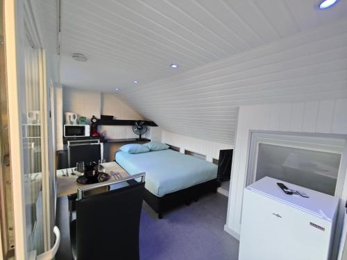 a bedroom with a bed and a desk with a computer at Chambre confortable 2P avec Terasse in Ostend