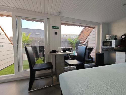 a bedroom with a bed and a table and chairs at Chambre confortable 2P avec Terasse in Ostend