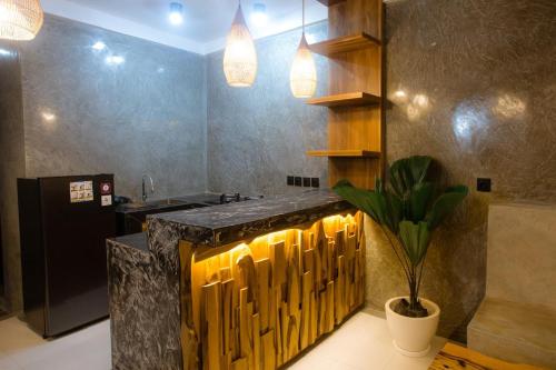 a kitchen with a counter and a potted plant at JeKa Escotel & Loft in Seminyak