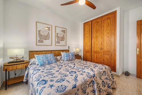 a bedroom with a bed with a blue and white comforter at Callao Beach 9 in Arrieta