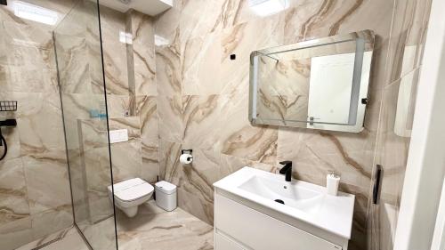 a bathroom with a sink and a toilet and a mirror at DREAM HOUSE Apartaments in Bistriţa