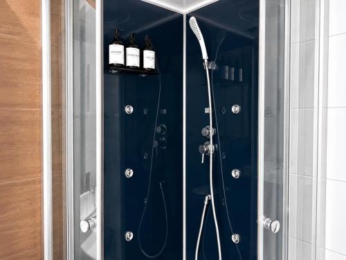 a bathroom with a shower with two bottles of alcohol at Velocity boutique hotel in Zandvoort