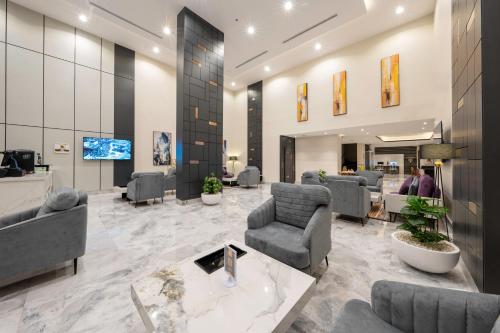 a lobby with couches and chairs and a television at Garden Melenium - Jeddah in Jeddah