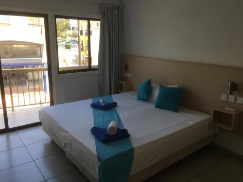 a bedroom with a bed with two towels on it at Mandali Court in Ayia Napa