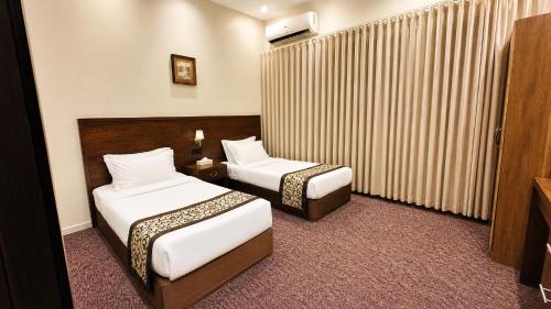 a hotel room with two beds and a television at Dome El Nozha in Riyadh