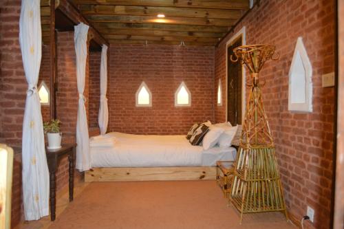 a bedroom with a bed in a brick wall at Yamba Traditional Home in Pātan