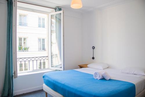 a bedroom with a bed and a large window at Hotel La Louisiane in Paris