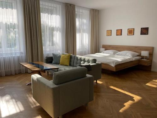 a living room with a couch and a bed at Hotel Zámeček na Čeladné in Čeladná