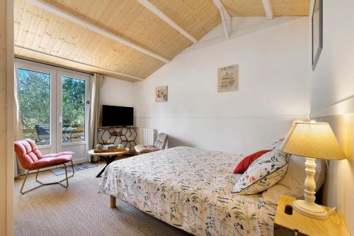a bedroom with a bed with a lamp and a chair at Maison d'hôtes Au Cocon de Verdure in Châteauneuf