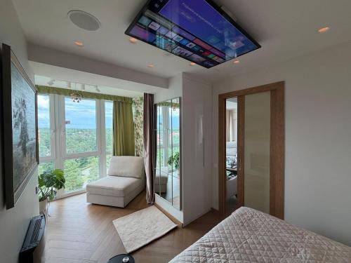 a bedroom with a bed and a television on the ceiling at ViSky Ap in Visaginas