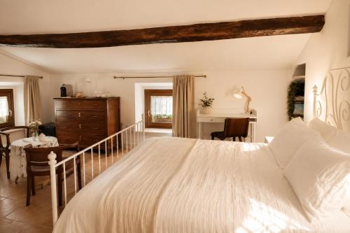 a bedroom with a large white bed and a desk at Casa Due Marie Boutique stay near Modena & Maranello in Marano sul Panaro