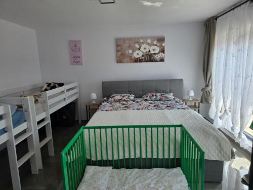 a bedroom with a green and white bed and a desk at Villa Violand in Limanu