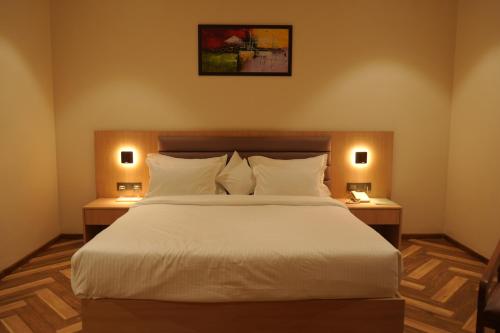 a bedroom with a large bed with two night stands at Hotel Tavijay in Jhunjhunūn