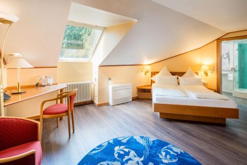 a hotel room with two beds and a desk at Hotel Asemann Planegg in Planegg