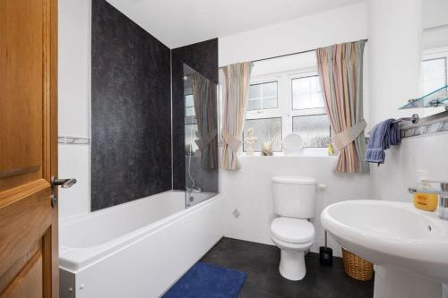 a bathroom with a white toilet and a sink at Turner's Corner by Escape Ordinary in Aghadowey