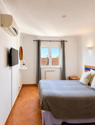 a bedroom with a large bed and a window at Grupo Morgado - Quinta do Morgado - Morgado Privilege in Tavira