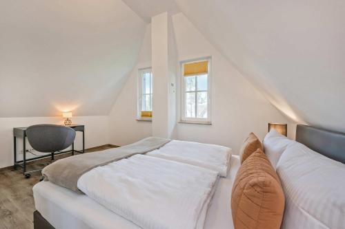 a white bedroom with a bed and a chair at Fischerdorf Ferienhaus JoHann in Zirchow