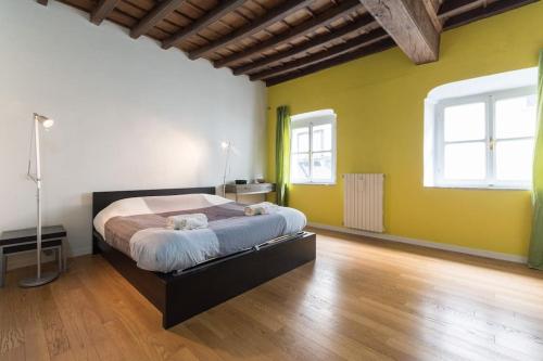 een slaapkamer met een groot bed en gele muren bij La tua casa nel Quadrilatero in Turijn