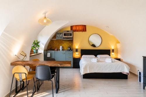 a bedroom with a bed and a table and a kitchen at Casa Anastasia with private patio by GardaDoma in Brenzone sul Garda