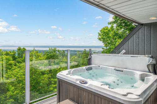 a jacuzzi tub on a balcony with a view at The Perch - Spa & Pool in Beaupré