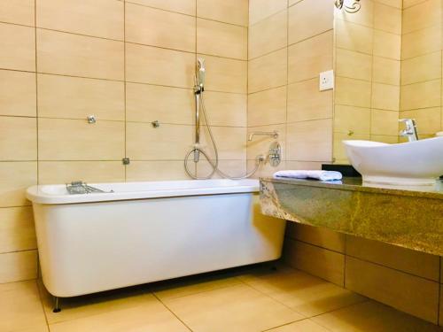 a bathroom with a bath tub and a sink at Radiant Resort in Manzini