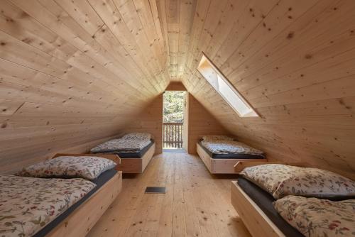 a room with three beds in a wooden cabin at Ochsenwaldhütte in Teschrepl