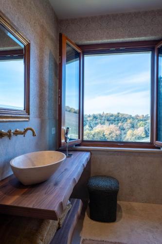 a bathroom with a large tub and a large window at Tolaini Winery Suites in Castelnuovo Berardenga