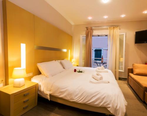 a bedroom with a large white bed and a couch at The Golden Nest Corfu in Corfu