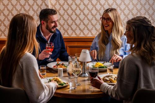 a group of people sitting around a table eating food at Patterdale Hotel in Patterdale