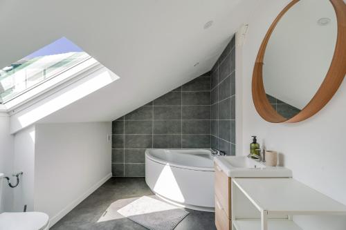 a bathroom with a white tub and a sink at Cocon au fond du jardin in Souffelweyersheim