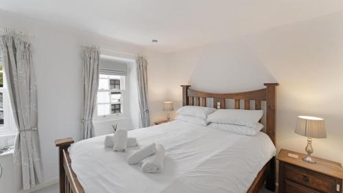 a bedroom with a white bed with two towels on it at 1 Bed in Hawkshead oc-lr067 in Hawkshead
