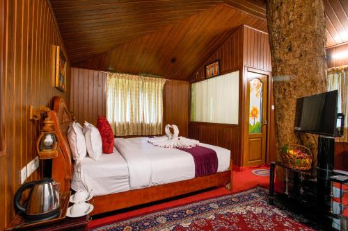 a bedroom with a bed and a tv in a room at Soma Seven Springs Resort in Munnar